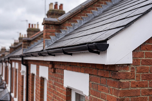 Clean guttering on brick terrace roofline (Roofing, Guttering & Exterior): "Clean, well-maintained guttering along a red-brick terrace roofline, roofing and guttering work in Chesterfield
